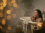 Woman in a bathtub holding a mug with blurred lights and plants in the background, relaxing scene.