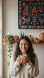 Woman holding a mug in a cozy room with plants and decorative wall art.
