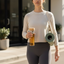 Woman holding a water bottle and yoga mat, walking outdoors.